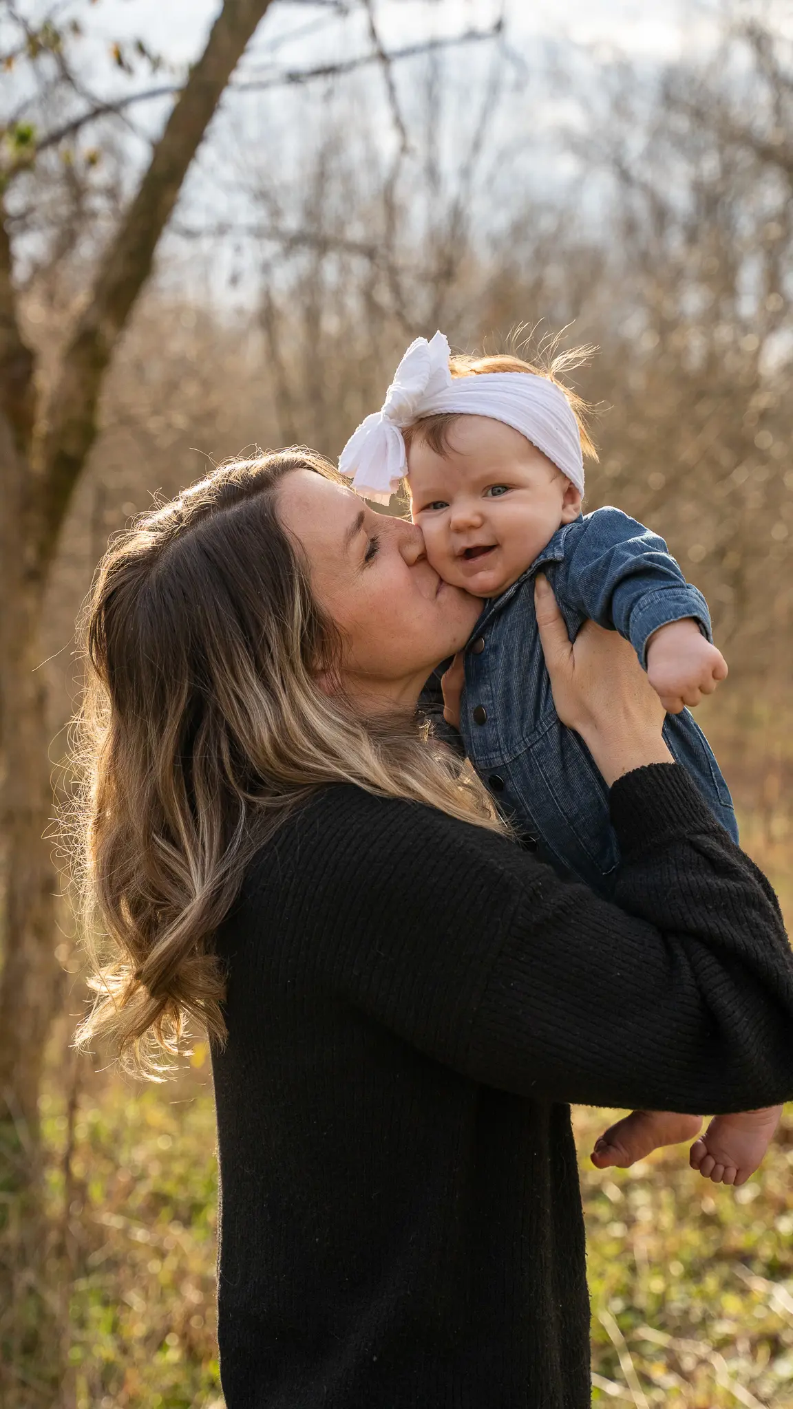 Mother kissing her baby daughter on the cheek